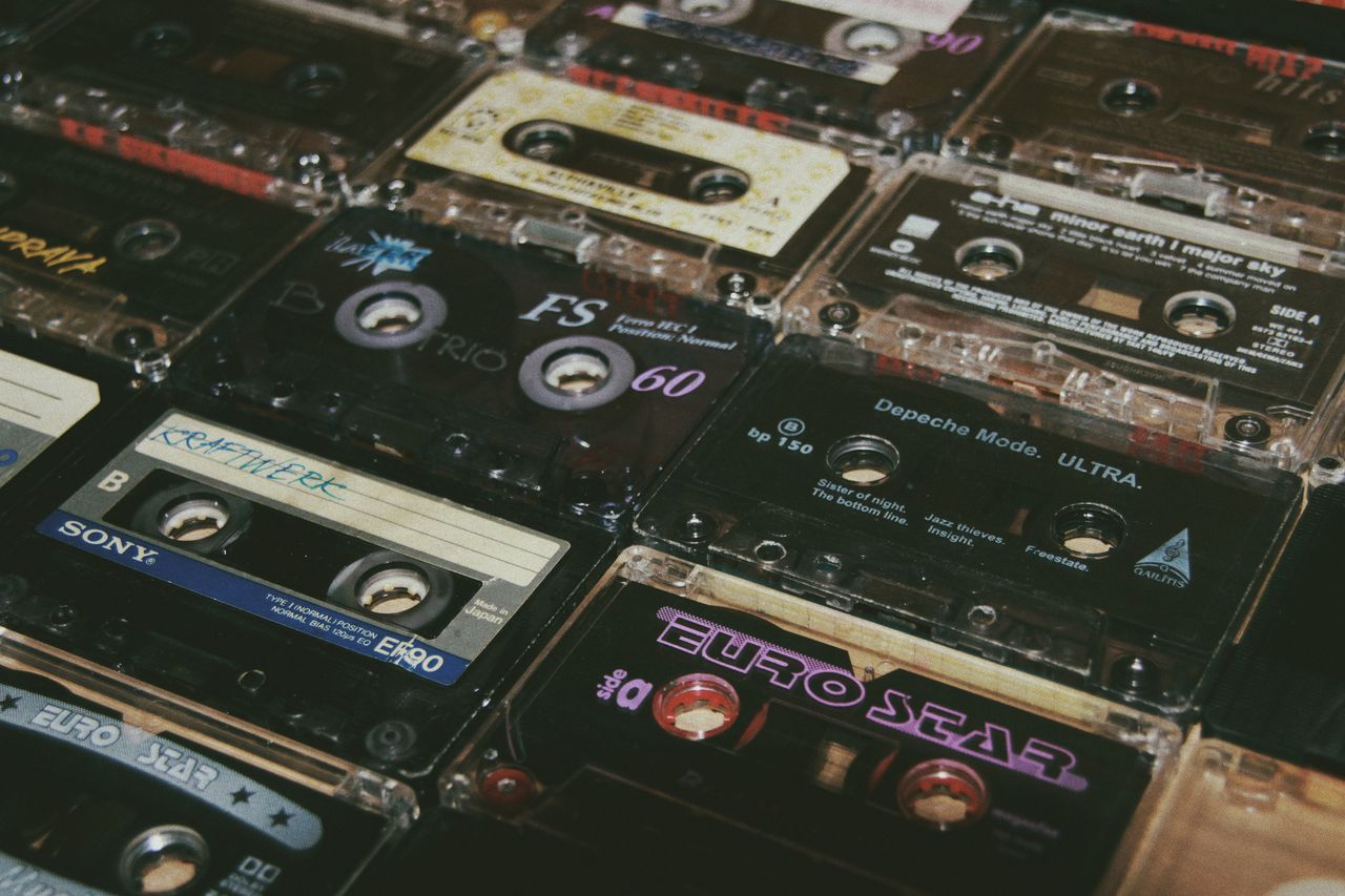 From above of various vintage audio cassettes with colorful inscriptions and numbers on surface at home